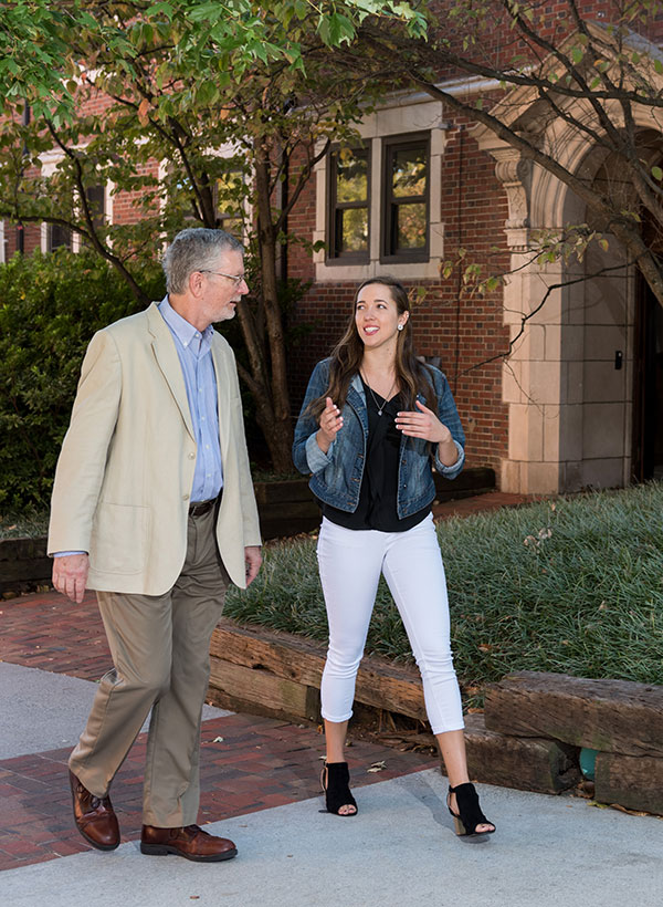 Professor and student walking while talking outside the Smith building
