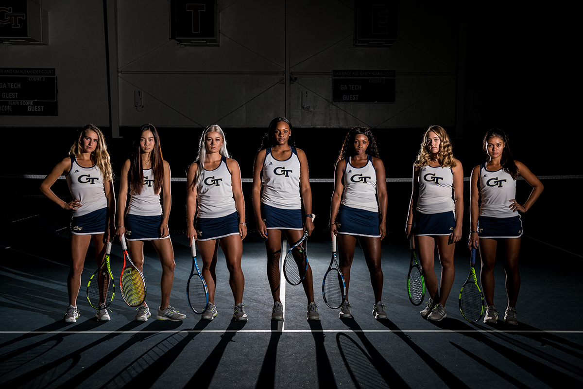 Tennis team players lined up for a group photo with dramatic lighting