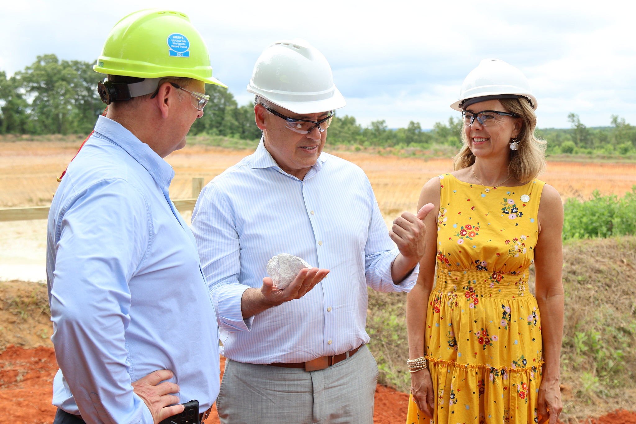 President Cabrera and Dr. Beth Cabrera in hard hats with a leader of Thiele Kaolin Company looking at Kaolin.